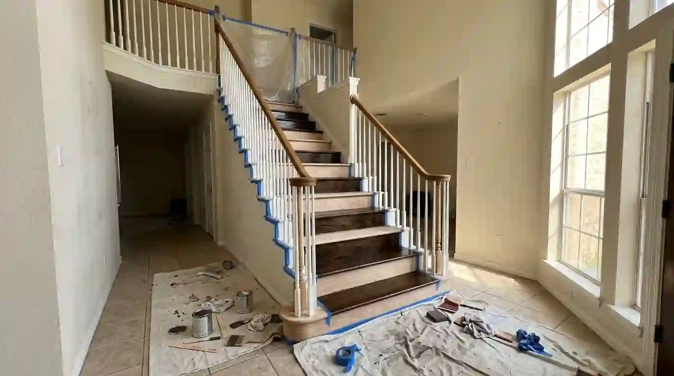 Staircase treads freshly stained dark walnut with white spindles